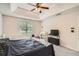 Comfortable bedroom featuring a tray ceiling, a cozy bed, and a crib with ample natural light at 4719 Score Ct, Snellville, GA 30039