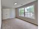 This bedroom features neutral walls, plush carpet, and a window providing natural light at 132 Garden Manor Ct, Loganville, GA 30052