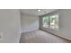 Bright bedroom featuring a neutral color scheme, plush carpet, and a window offering natural light at 132 Garden Manor Ct, Loganville, GA 30052