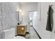 Stylish bathroom featuring patterned wallpaper, modern vanity, toilet, and a hallway entrance at 1805 Harvard Ave # 207, College Park, GA 30337