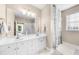 Bright bathroom featuring dual sinks, white cabinets, a large mirror, and a shower with glass doors at 2103 Stratford Commons, Decatur, GA 30033