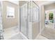 Clean bathroom with a glass enclosed shower, light tile flooring, neutral walls, and views into the bedroom at 2103 Stratford Commons, Decatur, GA 30033
