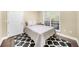 Minimalist bedroom with neutral walls, a black and white rug, a modern lamp, and wood flooring at 2103 Stratford Commons, Decatur, GA 30033