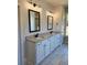 Elegant bathroom featuring a double vanity with granite countertops, white cabinets, and modern fixtures at 1685 Crumbley Rd, Mcdonough, GA 30252