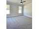 Spacious bedroom featuring neutral gray walls, plush gray carpet, and a modern ceiling fan with light at 1685 Crumbley Rd, Mcdonough, GA 30252