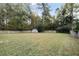 A large backyard with mature trees and a storage shed, providing ample space for outdoor activities and storage at 3568 Foxworth Ct, Buford, GA 30519