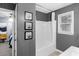 Bathroom showing shower/tub combination, gray walls, tile floor and decorative artwork on the wall at 3568 Foxworth Ct, Buford, GA 30519