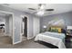 Well-lit bedroom showcases gray walls, plush carpeting, a cozy bed with gray headboard and ceiling fan at 3568 Foxworth Ct, Buford, GA 30519