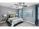 Comfortable bedroom featuring gray walls, a ceiling fan, and a plush bed with decorative pillows and teal accents at 3568 Foxworth Ct, Buford, GA 30519