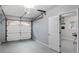 Garage with door leading to finished space with a painted floor. Includes garage door and ceiling mounted hardware at 3568 Foxworth Ct, Buford, GA 30519