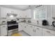 Bright kitchen features stainless steel appliances, granite countertops and white cabinets at 3568 Foxworth Ct, Buford, GA 30519