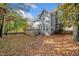 Backyard with a large deck and view of the house, surrounded by trees in autumn colors at 401 Briardale Court, Woodstock, GA 30189