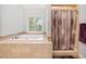 Bright bathroom with a large tub, stylish shower curtain, and a garden window at 401 Briardale Court, Woodstock, GA 30189