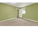 Bright bedroom featuring neutral carpet, green walls, and a white door to a hallway at 4653 Anns Se Trce, Acworth, GA 30102
