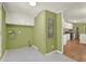 Laundry room with green walls, gray floors, and white cabinets, conveniently near the kitchen at 4653 Anns Se Trce, Acworth, GA 30102