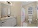 Bright bathroom featuring a white vanity, mirror, and toilet with a floral shower curtain at 536 Crestridge Ct, Stone Mountain, GA 30083