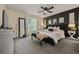 Spacious main bedroom with a dark accent wall, decorative mirrors, and a ceiling fan at 536 Crestridge Ct, Stone Mountain, GA 30083