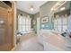 Stylish bathroom with double vanity, walk-in shower, and window seat beneath bright window at 7420 Colony Ct, Cumming, GA 30041