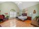 Spacious bedroom featuring vaulted ceilings, hardwood floors, and a large arched window at 7420 Colony Ct, Cumming, GA 30041