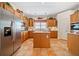 Traditional kitchen featuring wood cabinets, stainless steel appliances, and a central island with tiled floors at 7420 Colony Ct, Cumming, GA 30041