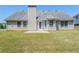 Home's backyard featuring a chimney, patio, and expansive lawn at 811 Betsy Ross Trl, Hampton, GA 30228