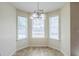 Charming breakfast nook with a modern chandelier and natural light from three windows with crisp white blinds at 811 Betsy Ross Trl, Hampton, GA 30228