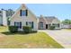 Traditional two-story home featuring vinyl siding, black shutters, mature landscaping, and a concrete driveway at 811 Betsy Ross Trl, Hampton, GA 30228