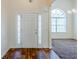 Bright foyer features a decorative glass sidelight door, hardwood floors, and an arched window at 811 Betsy Ross Trl, Hampton, GA 30228