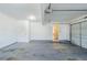 Clean, open two-car garage featuring sealed concrete floor and access door at 811 Betsy Ross Trl, Hampton, GA 30228