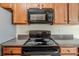 Close-up view of a black stove top and stainless steel microwave in a kitchen at 811 Betsy Ross Trl, Hampton, GA 30228