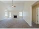 Spacious living room with vaulted ceilings, plush carpeting, a ceiling fan, and a cozy fireplace at 811 Betsy Ross Trl, Hampton, GA 30228