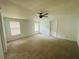 Large carpeted bedroom with natural light, ceiling fan, and neutral decor at 14 Craig Dr, Conyers, GA 30012