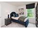 Cozy bedroom featuring stylish blue bed frame, nightstand, and a window with natural light at 1573 Aiden Way # 37, Conyers, GA 30013