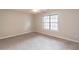 Carpeted bedroom featuring a ceiling fan, neutral paint, and a large window at 1241 Hogan Ridge Ct, Grayson, GA 30017
