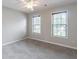 Comfortable carpeted bedroom featuring neutral walls and bright, natural light from two windows at 1241 Hogan Ridge Ct, Grayson, GA 30017