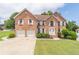 Charming brick home with a well-kept lawn, two-car garage, and a classic white front door at 1241 Hogan Ridge Ct, Grayson, GA 30017