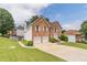 Beautiful two-story brick home with an attached two-car garage and a green, landscaped front yard at 1241 Hogan Ridge Ct, Grayson, GA 30017