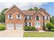 Elegant brick home featuring a two-car garage, manicured lawn, and symmetrical window shutters at 1241 Hogan Ridge Ct, Grayson, GA 30017