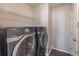 A modern laundry room equipped with a front-load washer and dryer and wire rack shelving at 1241 Hogan Ridge Ct, Grayson, GA 30017