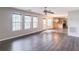Spacious living room with wood flooring, natural light from multiple windows, and an eat-in kitchen in the background at 1241 Hogan Ridge Ct, Grayson, GA 30017