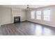 The living room features wood flooring, a decorative fireplace, ceiling fan, and natural light from three windows at 1241 Hogan Ridge Ct, Grayson, GA 30017