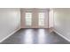 Bright living room with hardwood floors, two windows, and white trim at 1241 Hogan Ridge Ct, Grayson, GA 30017
