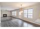Bright living area with wood flooring, a fireplace, modern light fixtures, and several windows for natural light at 1241 Hogan Ridge Ct, Grayson, GA 30017