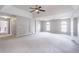 Open main bedroom with tray ceilings, carpet flooring, columns, and access to a bathroom, providing convenience at 1241 Hogan Ridge Ct, Grayson, GA 30017