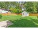 Large backyard with a well-maintained lawn, a storage shed, and a wooden fence for privacy at 2037 Lenox Ne Rd, Atlanta, GA 30324