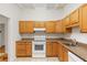 Well-lit kitchen featuring matching appliances, wooden cabinets, stone-look countertops, and tile flooring at 2037 Lenox Ne Rd, Atlanta, GA 30324