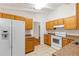 Well-lit kitchen featuring matching appliances, wooden cabinets, stone-look countertops, and tile flooring at 2037 Lenox Ne Rd, Atlanta, GA 30324