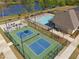 Aerial view of community amenities including a pool, pickleball court, and bocce ball court, all near a scenic lake at 2526 Knob Creek Dr, Snellville, GA 30078