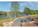 Community fire pit with seating area, adjacent to a scenic lake and lush green surroundings at 2526 Knob Creek Dr, Snellville, GA 30078