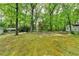 Lush, green backyard showing mature trees, storage building, and carport, offering a private, serene environment at 2963 Williams Pl, Snellville, GA 30078